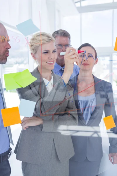 Businesswoman drawing graph on the board — Stock Photo, Image