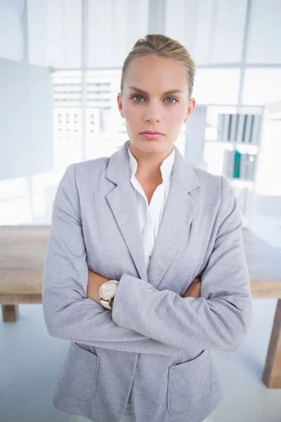Unhappy businesswoman looking at camera with arms crossed — 图库照片