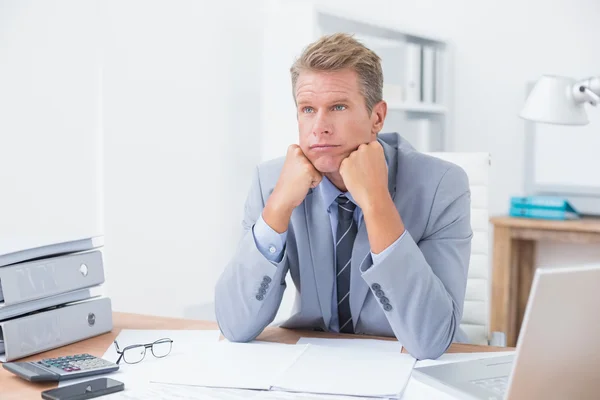 Worried businessman sitting at work — Stok fotoğraf
