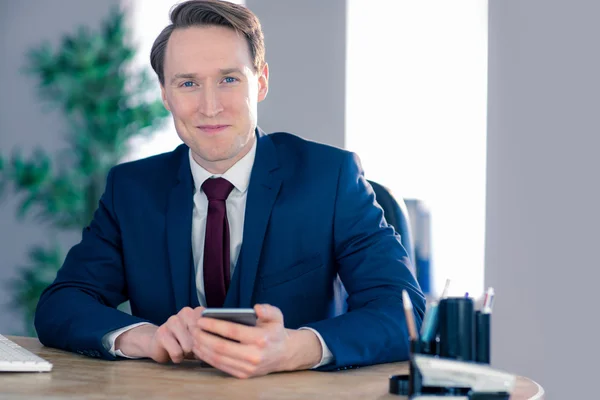 Hombre de negocios seguro con teléfono inteligente mirando a la cámara — Foto de Stock