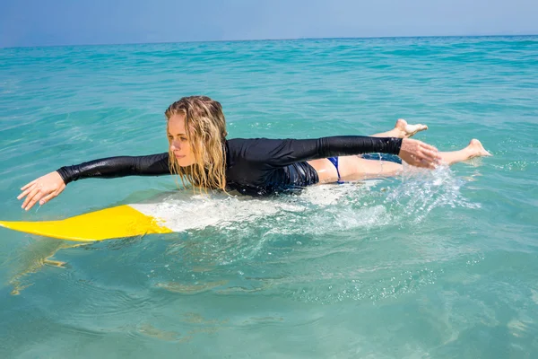 Femme avec une planche de surf par une journée ensoleillée — Photo