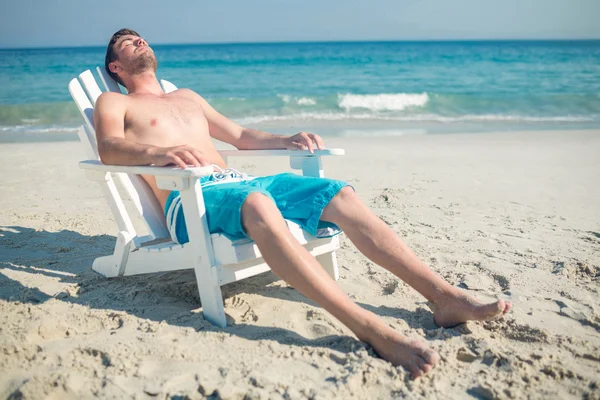 Człowiek relaks na leżaku na plaży — Zdjęcie stockowe