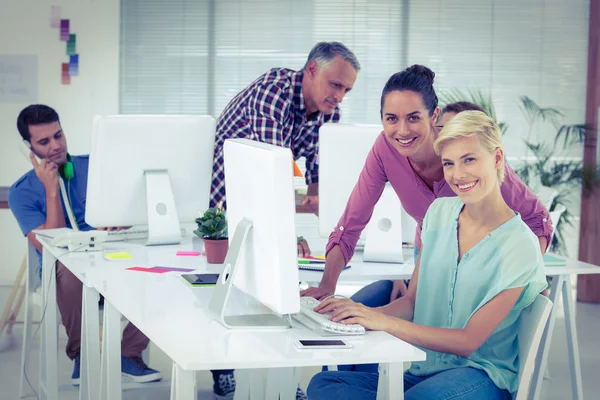 Lachende foto-editors met behulp van de computer in kantoor — Stockfoto