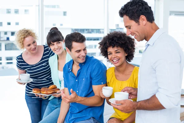 Mensen uit het bedrijfsleven donuts eten en drinken — Stockfoto