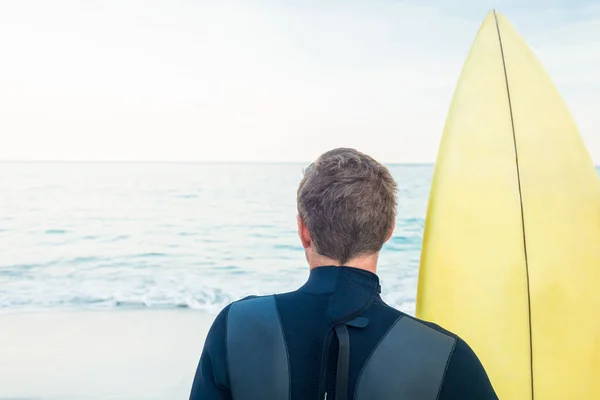 Man in wetsuit with a surfboard on a sunny day — Stock Photo, Image