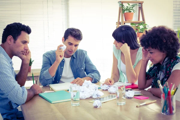 Exhausted business team making paper pellet — Stock Photo, Image