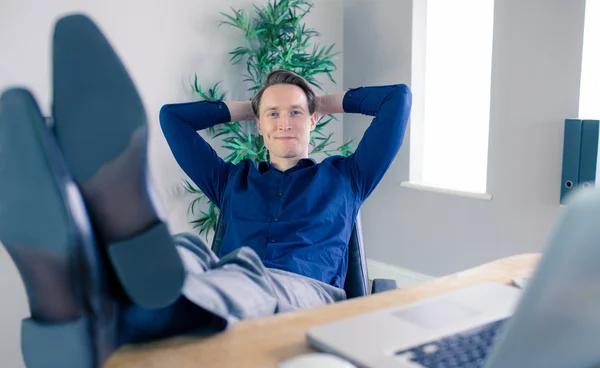 Hombre de negocios sonriente relajándose en una silla giratoria — Foto de Stock