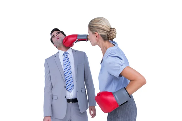 Businesswoman punching colleague with boxing gloves — Stock Photo, Image