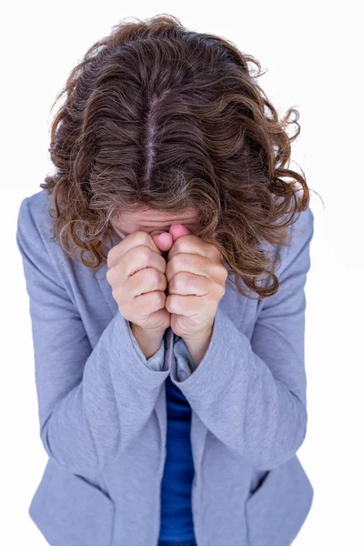 Brünette beten mit hand auf kopf — Stockfoto