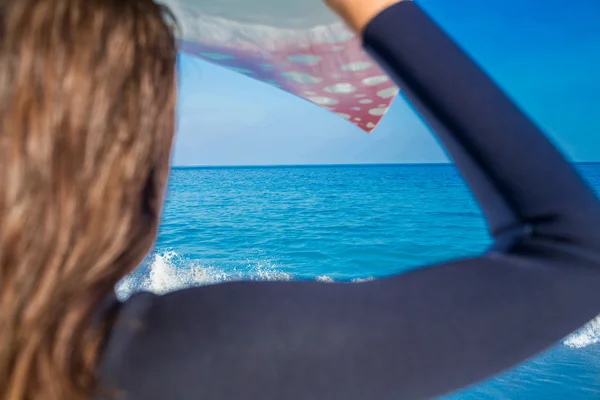 Vrouw in wetsuit met een surfplank op een zonnige dag — Stockfoto