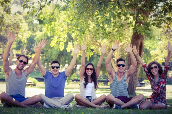 Des amis heureux levant la main dans le parc — Photo