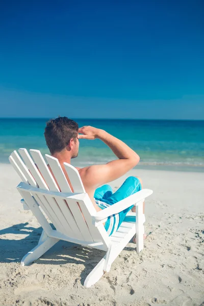 Man koppla av på en solstol på stranden — Stockfoto
