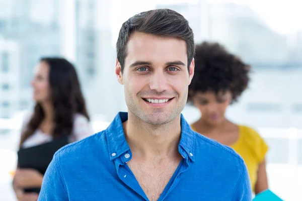 Lachende zakenman met zijn collega's achter — Stockfoto