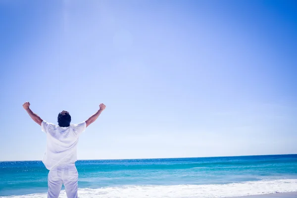 Homem estendendo os braços em frente ao mar — Fotografia de Stock