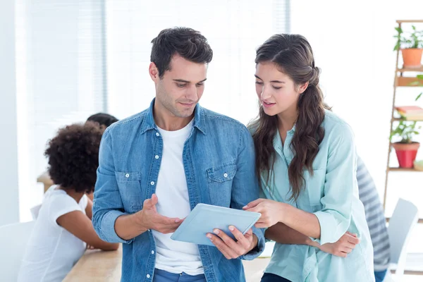 Young business people discussing over a tablet — Stock Photo, Image