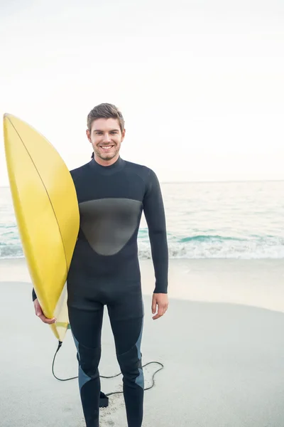 Mannen i våtdräkt med en surfbräda på en solig dag — Stockfoto