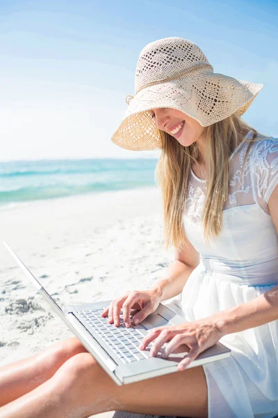 Mujer usando portátil y usando sombrero — Foto de Stock