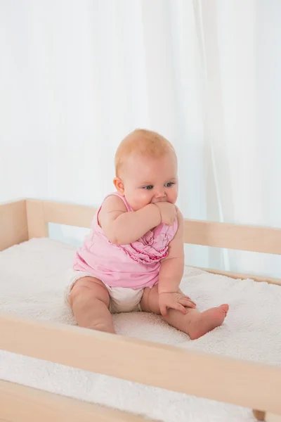Cute baby girl in her bed — Stockfoto