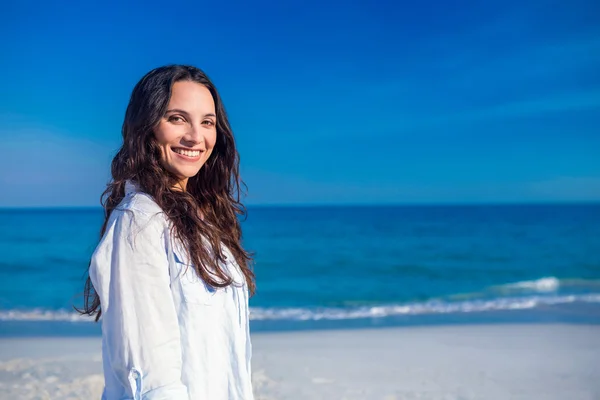 Sorridente donna guardando la fotocamera in spiaggia — Foto Stock