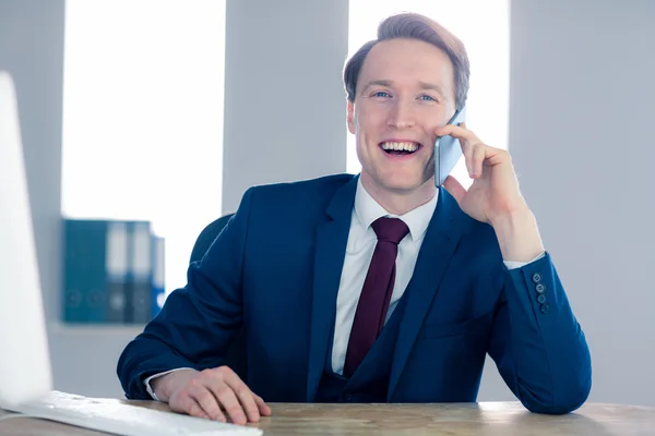 Leende affärsman med ett telefonsamtal — Stockfoto