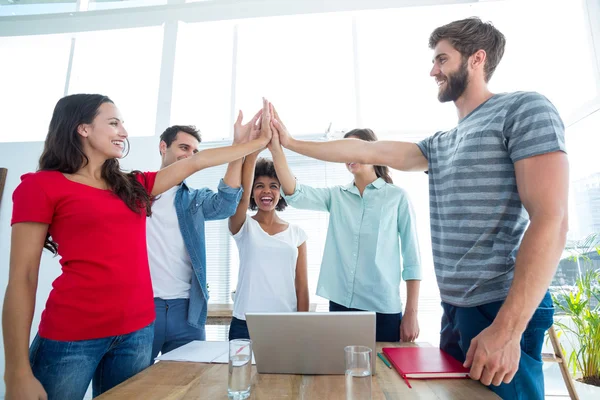 Equipe de negócios feliz colocando as mãos juntas — Fotografia de Stock