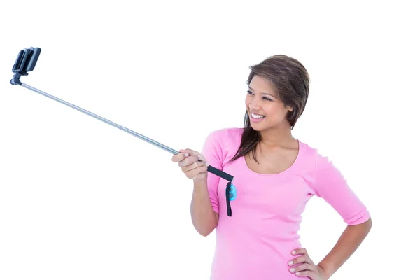 Jolie brune utilisant un selfie stick — Photo