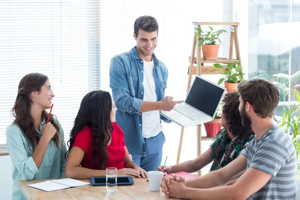 Jungunternehmer zeigt Kollegen seinen Laptop — Stockfoto