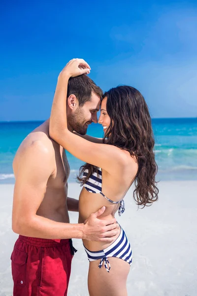Счастливая пара обнимается на пляже — стоковое фото
