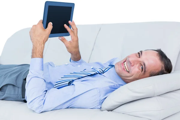 Pihentető üzletember egy kanapé, egy tabletta — Stock Fotó