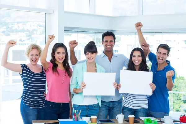 Happy business team holding a signboard — Stock Photo, Image