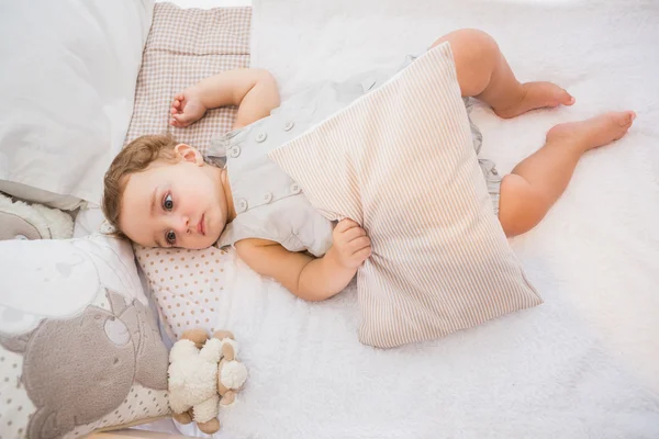 Child in bed with pillow — Stockfoto