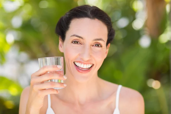 Woman in white having a glass of water — Stok fotoğraf