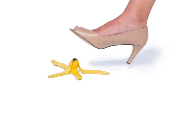 Woman with heel shoes walking on banana — Stock Photo, Image