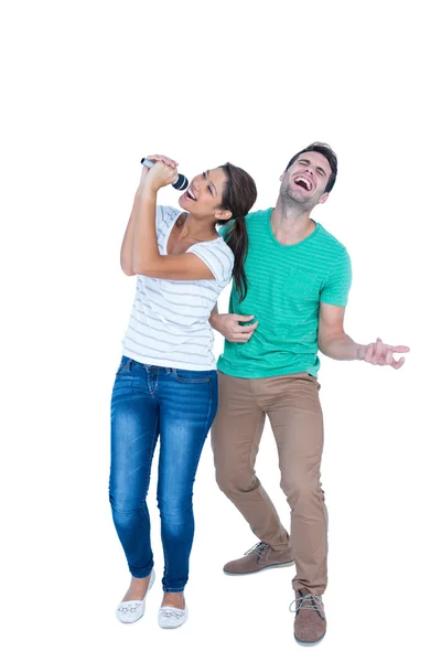 Friends singing in a microphone and playing air guitar — Stock Photo, Image