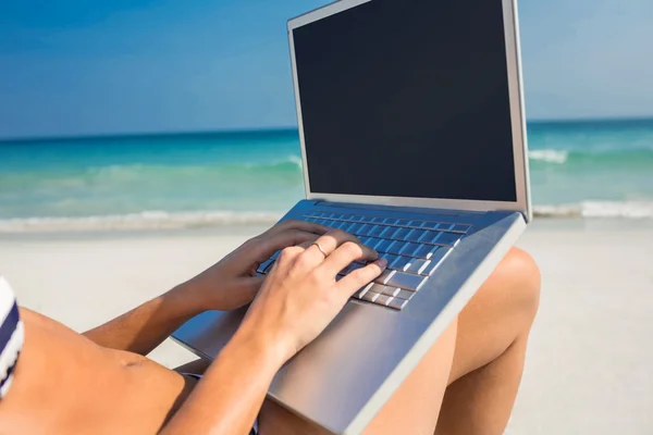 Woman using laptop on deck chair — Stock Photo, Image