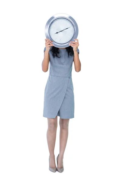 Geschäftsfrau hält große Uhr vor Gesicht — Stockfoto