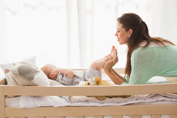 Mother using laptop with baby boy — Stockfoto