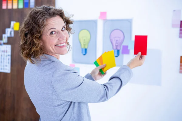 Pengusaha kreatif wanita memegang kartu warna — Stok Foto