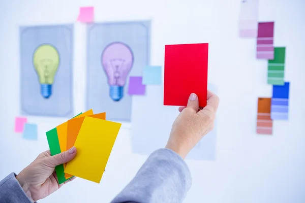 Empresaria creativa sosteniendo tarjetas de color — Foto de Stock