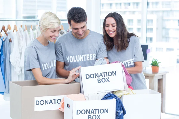 Voluntarios amigos revisando una lista de donaciones — Foto de Stock