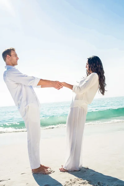 Par hålla händer och står på stranden — Stockfoto