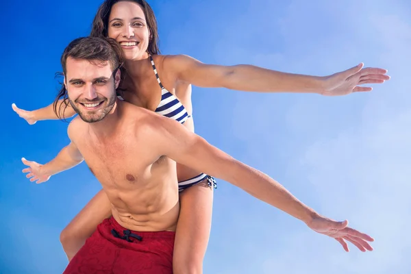 Uomo dando maialino torna alla sua ragazza in spiaggia — Foto Stock