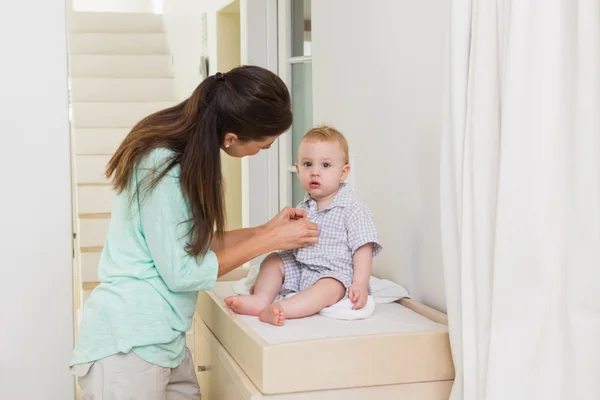 Mother dresses her baby boy — Stock Photo, Image