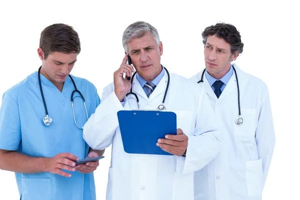 Doctor on phone holding clipboard — Stock Photo, Image