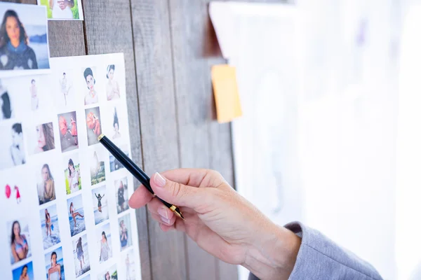 Empresária criativa apontando fotos com caneta — Fotografia de Stock