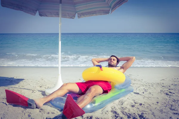 Mann liegt mit Schwimmflossen und Gummiring — Stockfoto