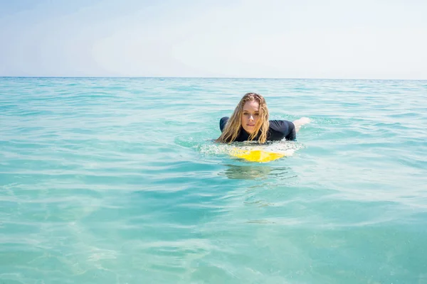 Mulher com prancha de surf num dia ensolarado — Fotografia de Stock