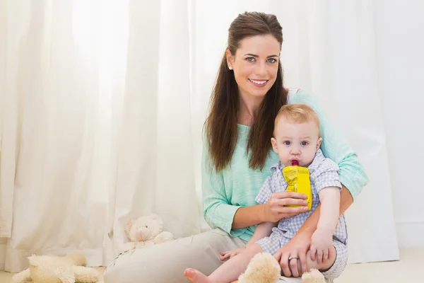 Mãe dando bebê uma bebida — Fotografia de Stock