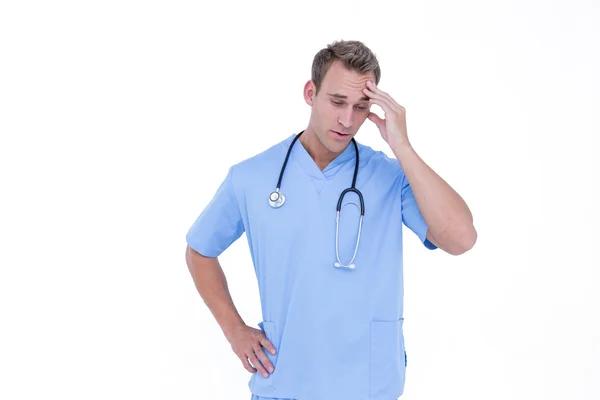 Worried young nurse in blue tunic — Stock Photo, Image