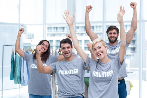 Happy volunteers friends raising arms — Stock Photo, Image